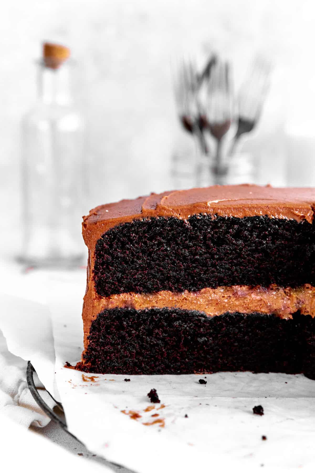 Chocolate cake in front of a jar of forks.