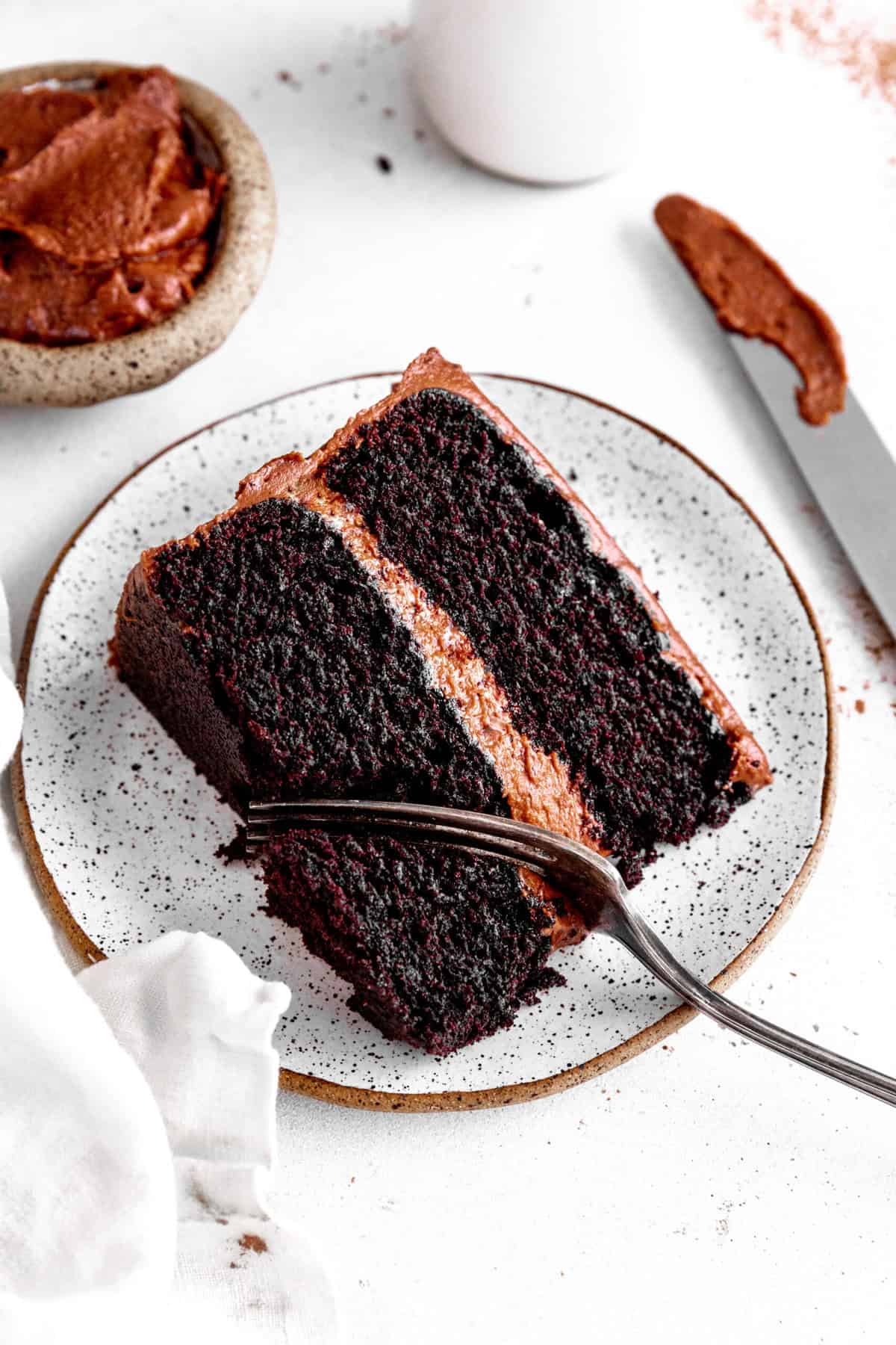 Fork cutting into a slice of chocolate cake.