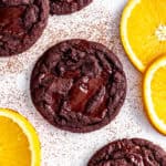 Orange chocolate cookie surrounded by fresh orange slices.