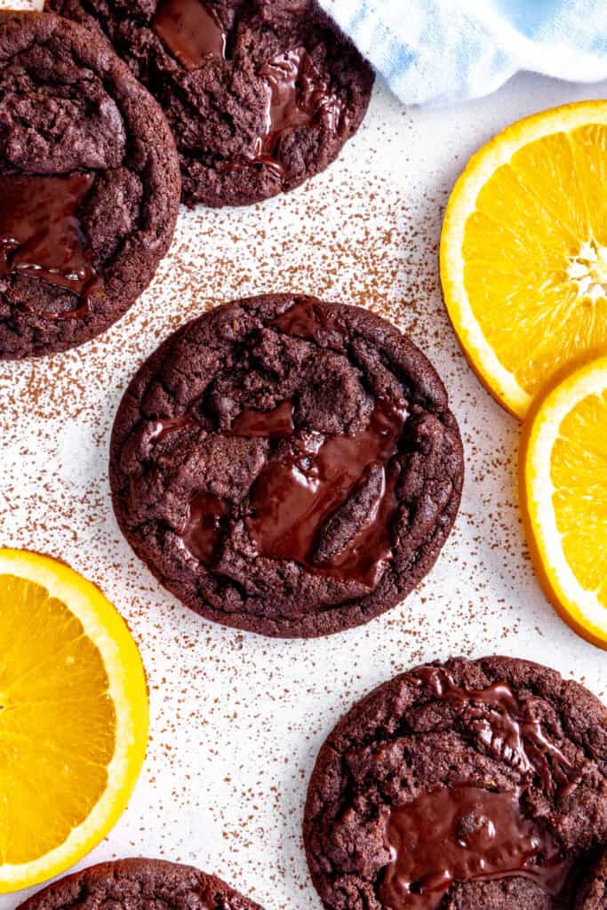 Orange chocolate cookie surrounded by fresh orange slices.