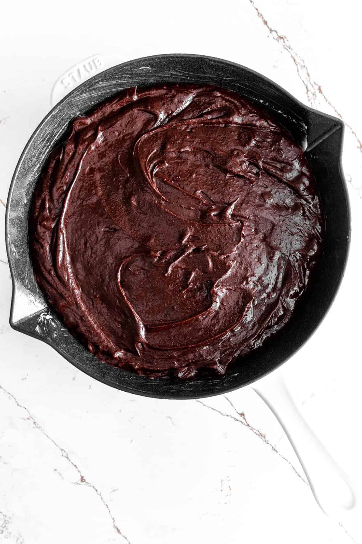 Unbaked brownie batter poured into a skillet.