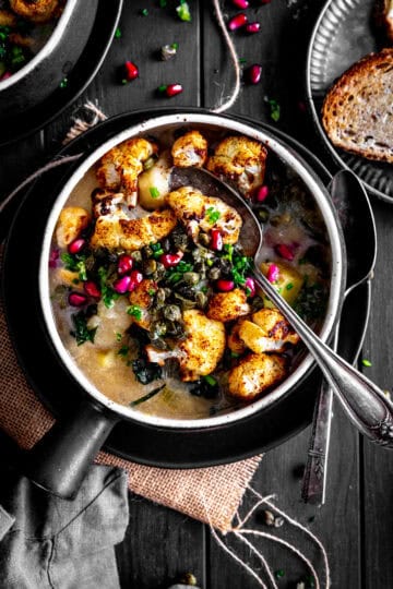 Spoon in a bowl of roasted cauliflower gnocchi soup.