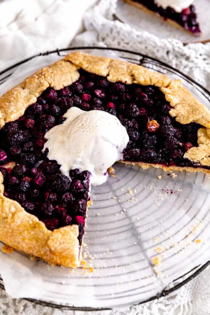 Blueberry galette on a wire rack with missing slices.