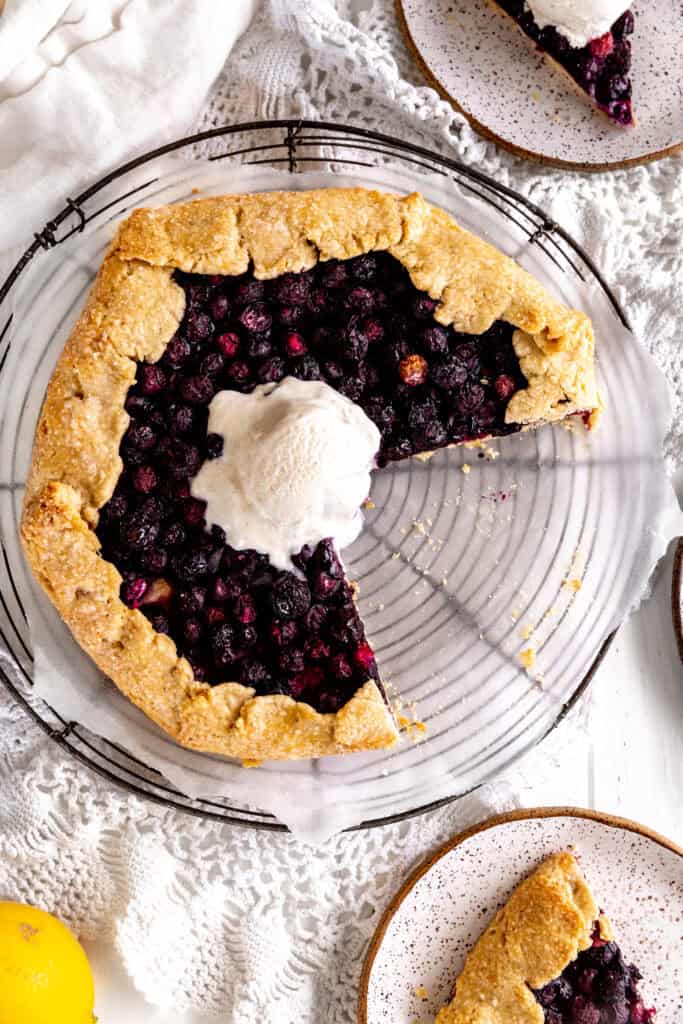 Blueberry galette on a wire rack with missing slices.