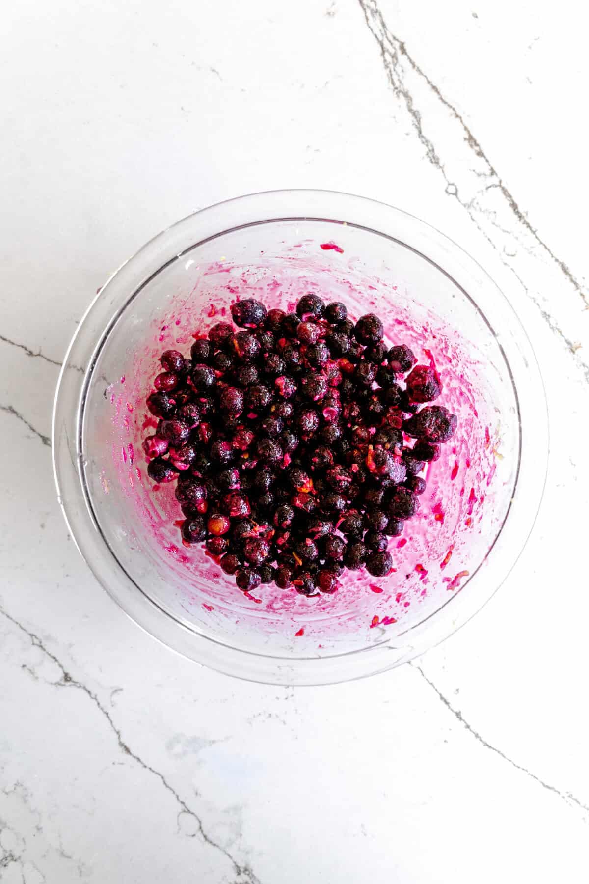 Glass bowl filled with blueberries tossed in sugar.