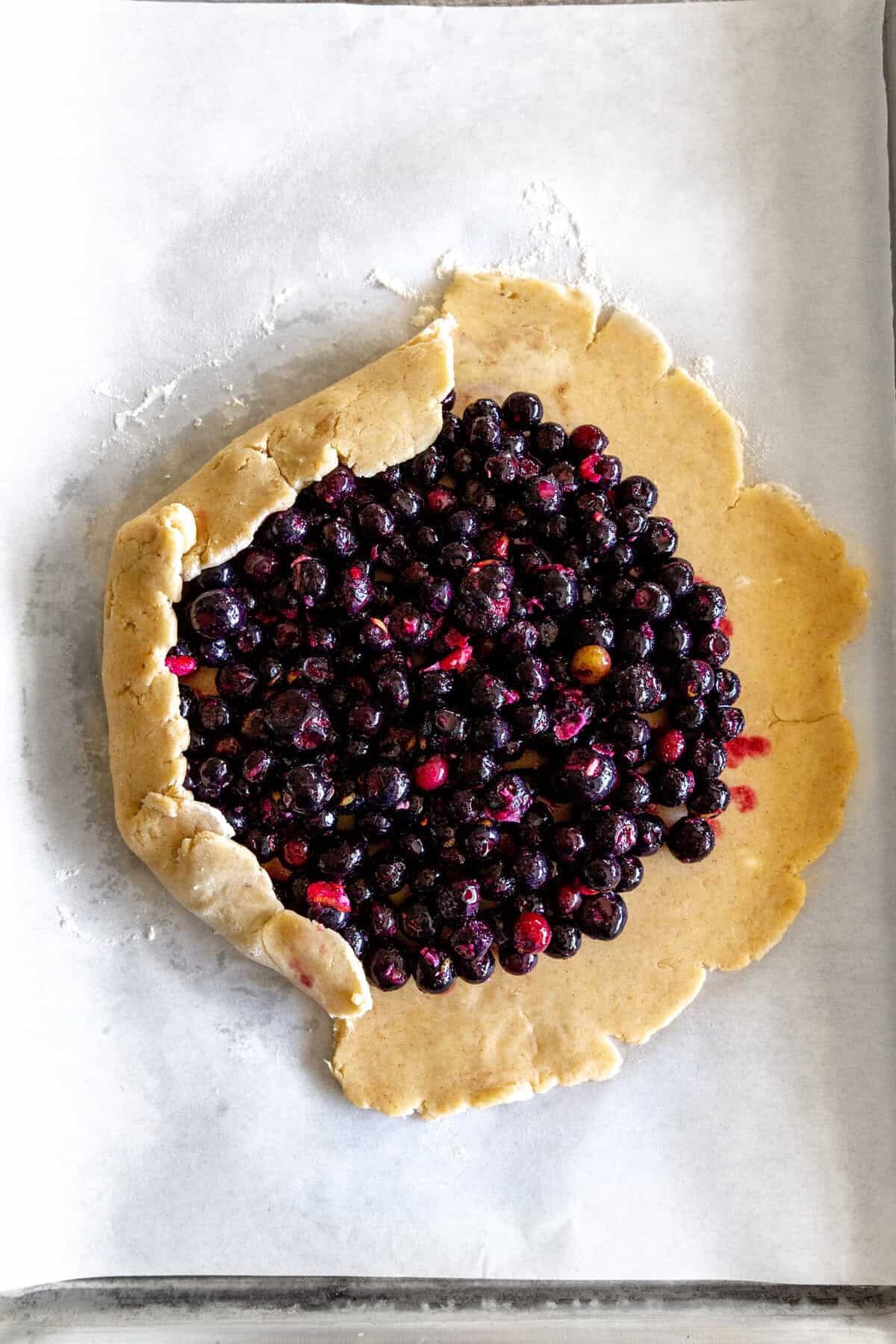 Unbaked and half-folded blueberry galette.
