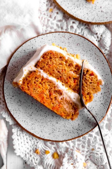 Fork cutting into a slice of carrot cake.