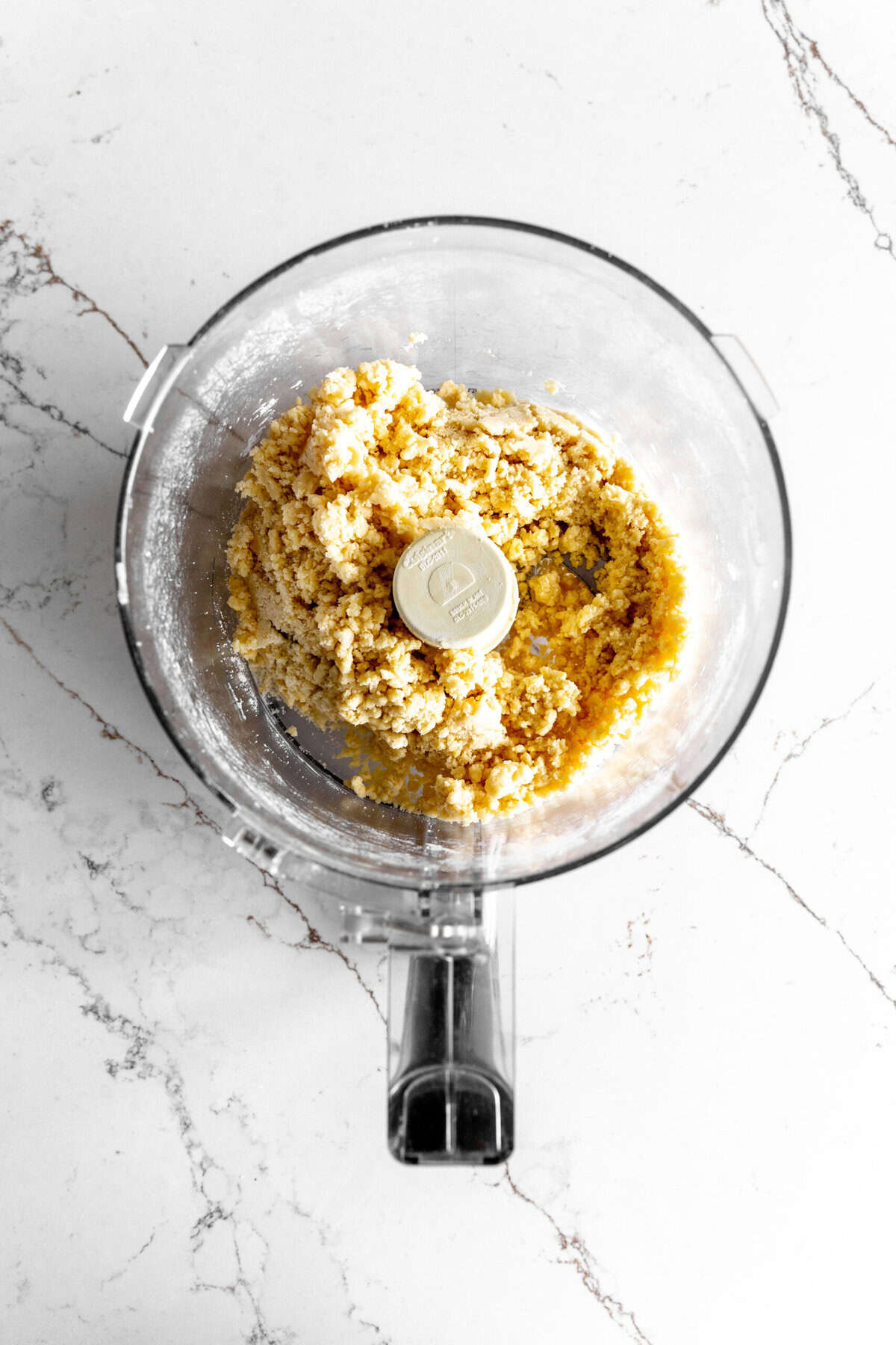 Food processor filled with shortbread dough.