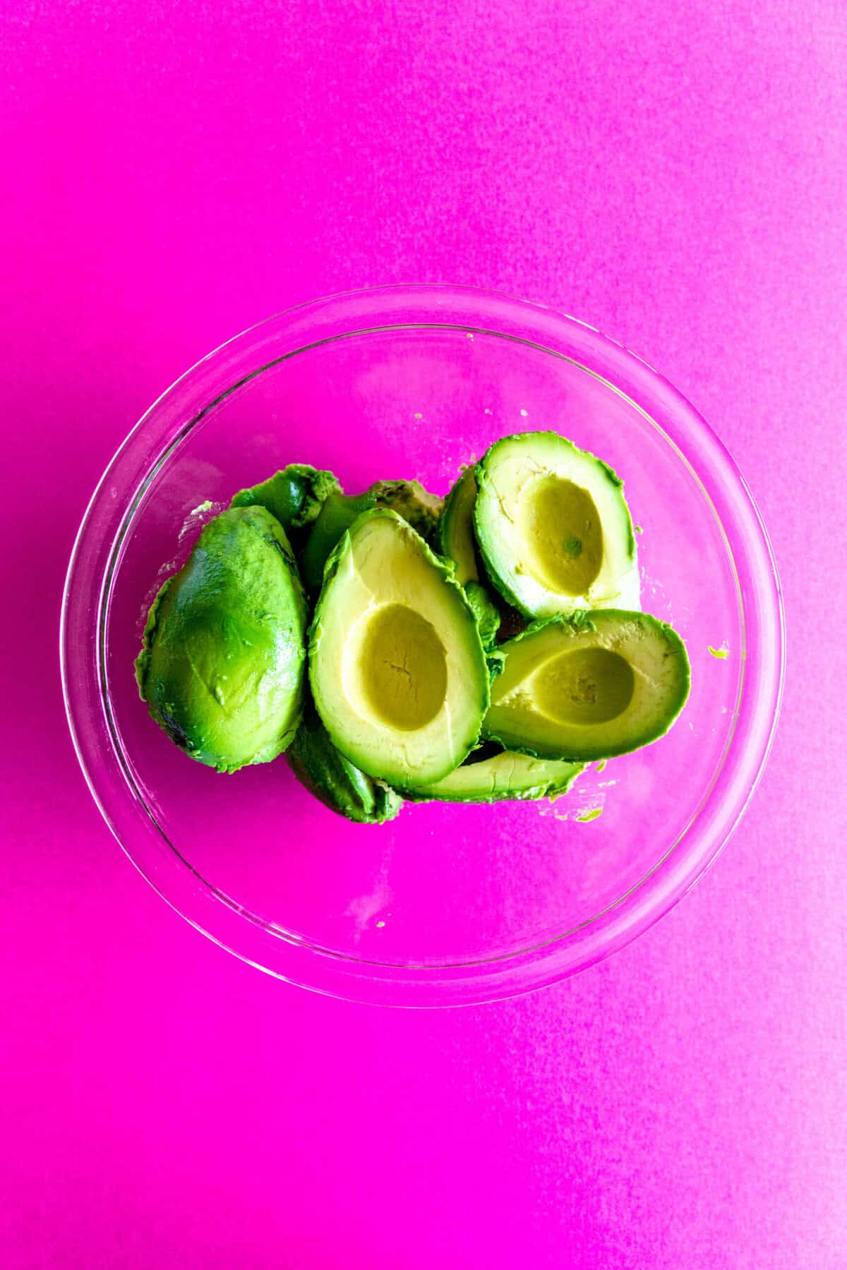glass bowl filled with avocado halves.