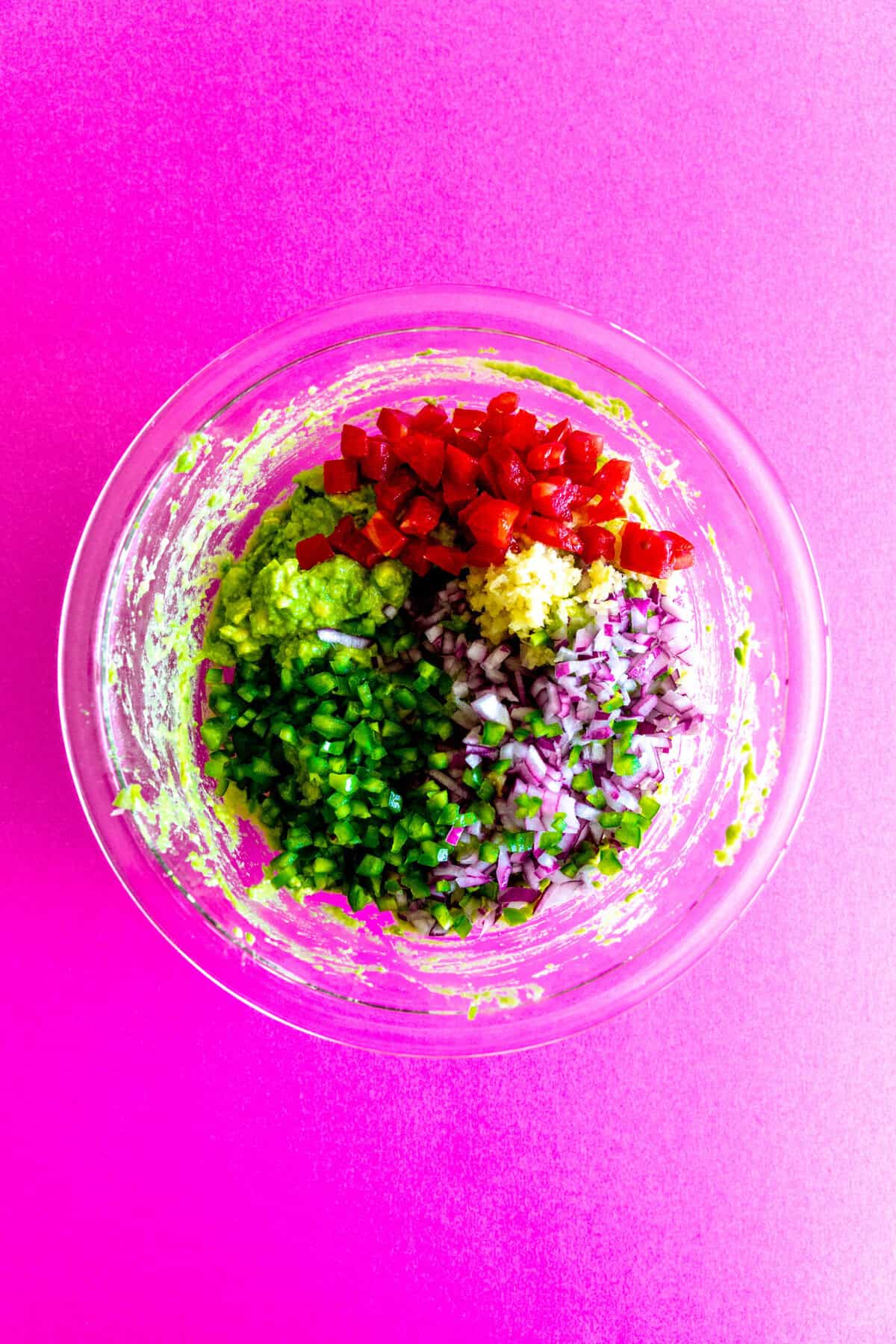 guacamole ingredients in a large glass bowl.
