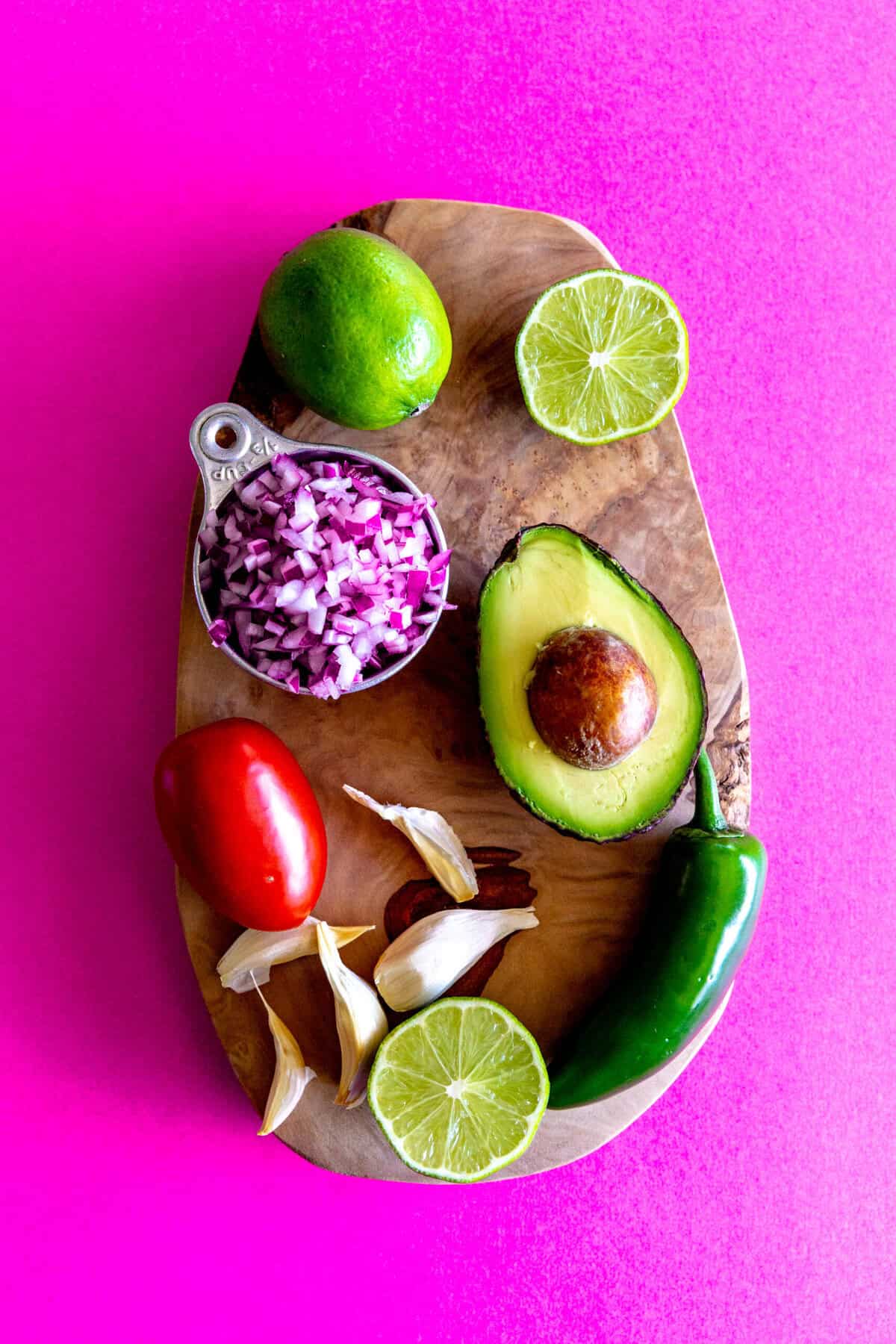 guacamole ingredients on a wooden cutting board.