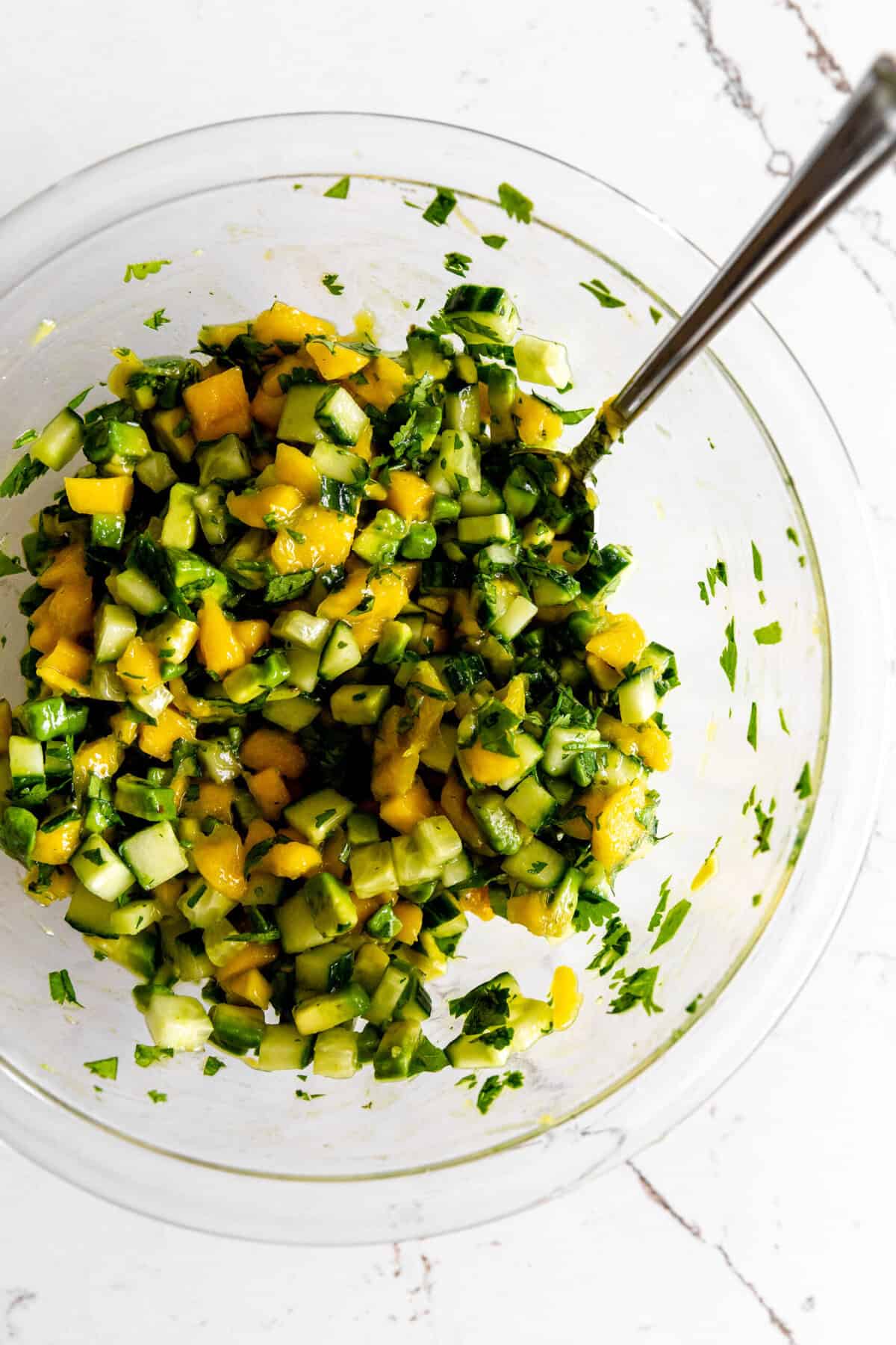 Cucumber-mango salsa in a glass bowl.