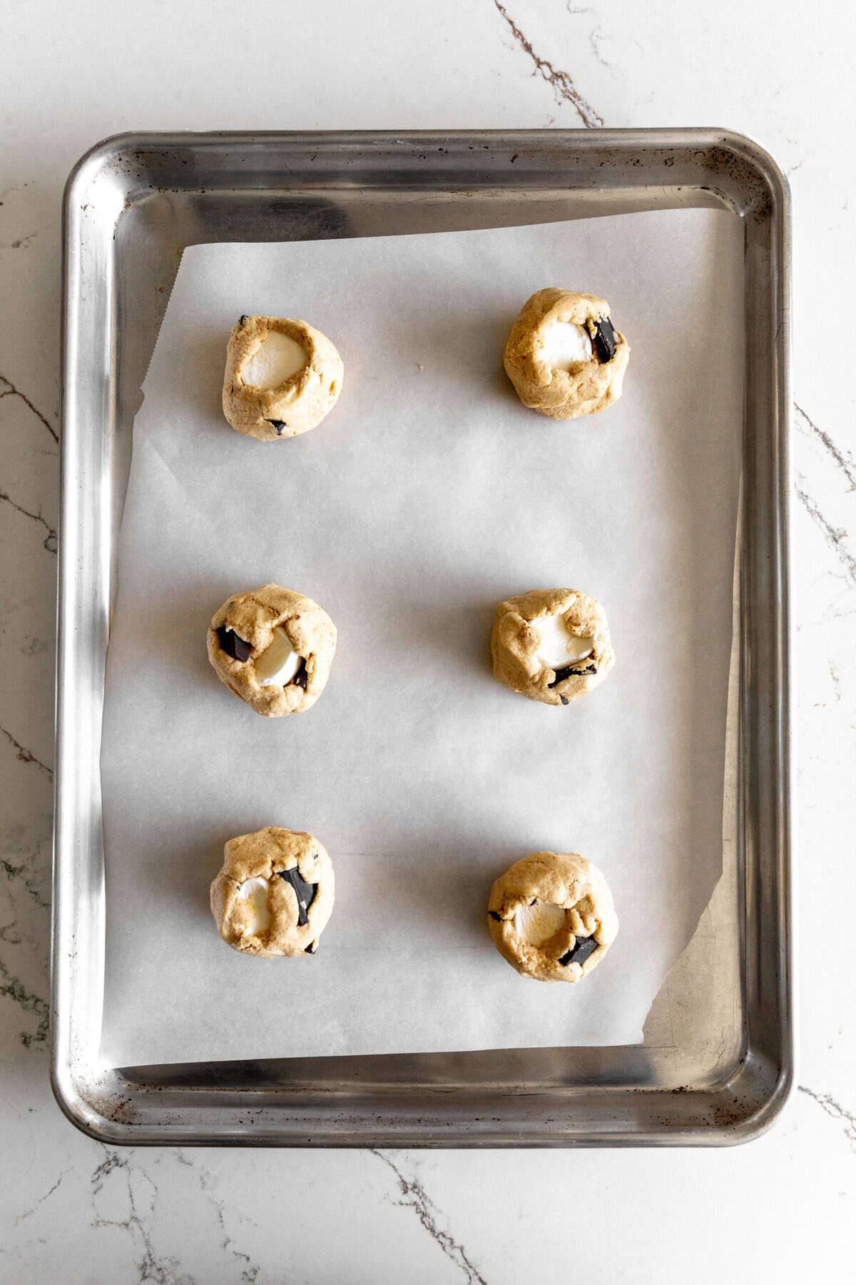 Unbaked s'mores cookies on a baking sheet.