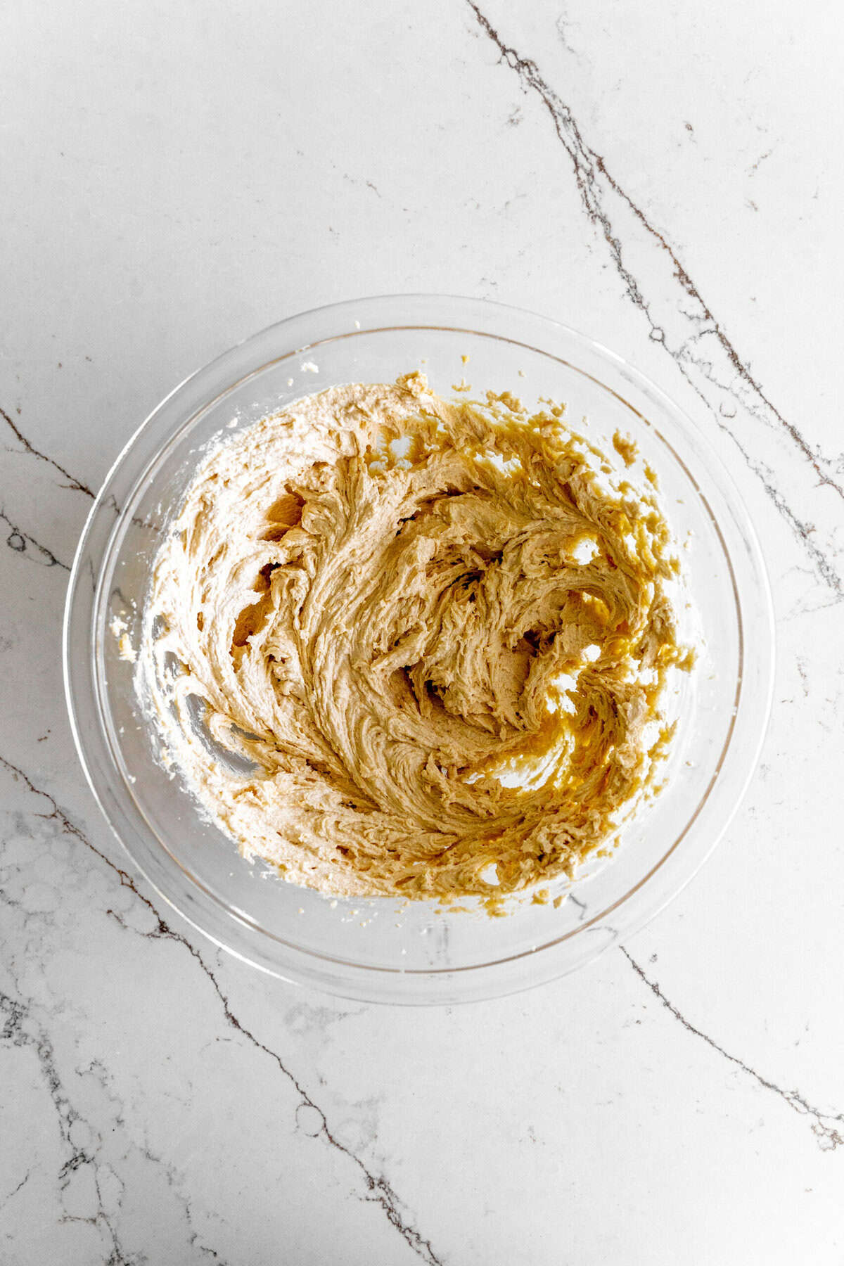 Glass bowl of creamed butter and sugar.