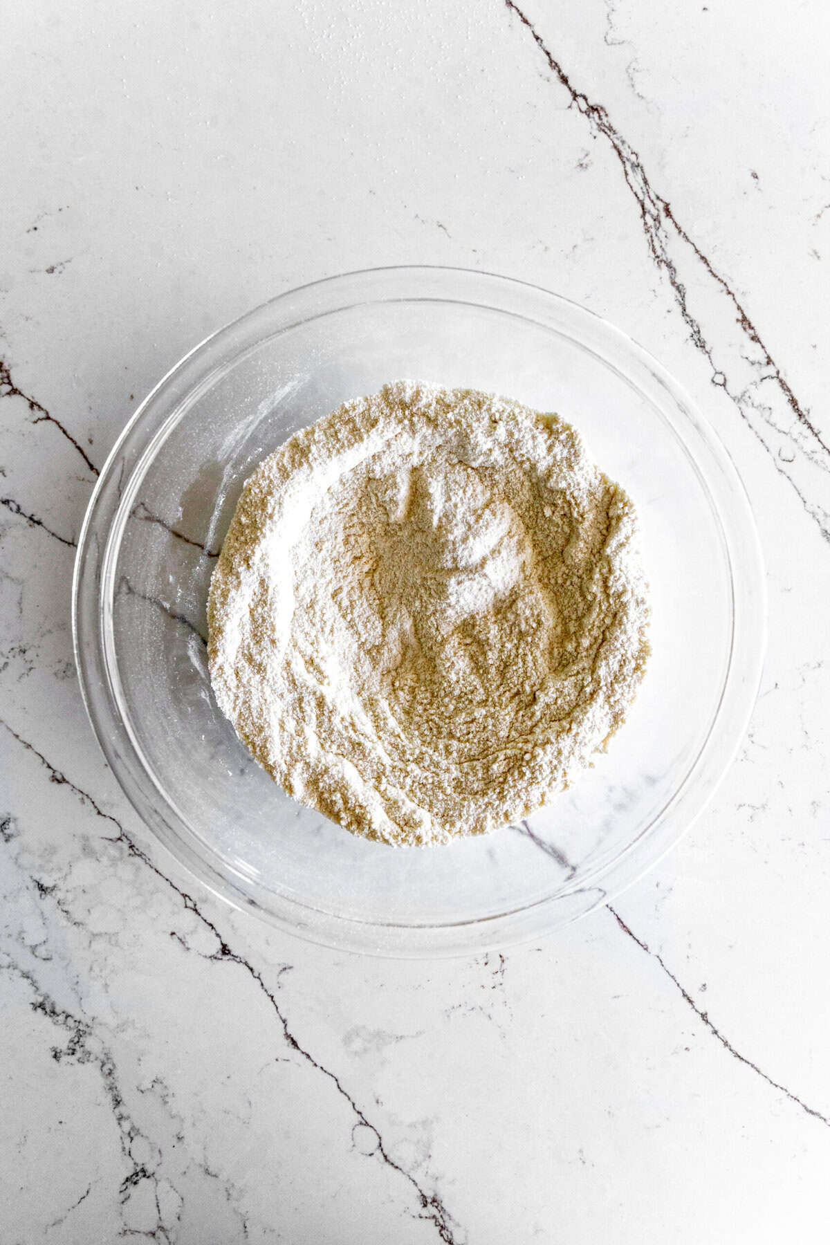 A bowl of flour on a marble counter.