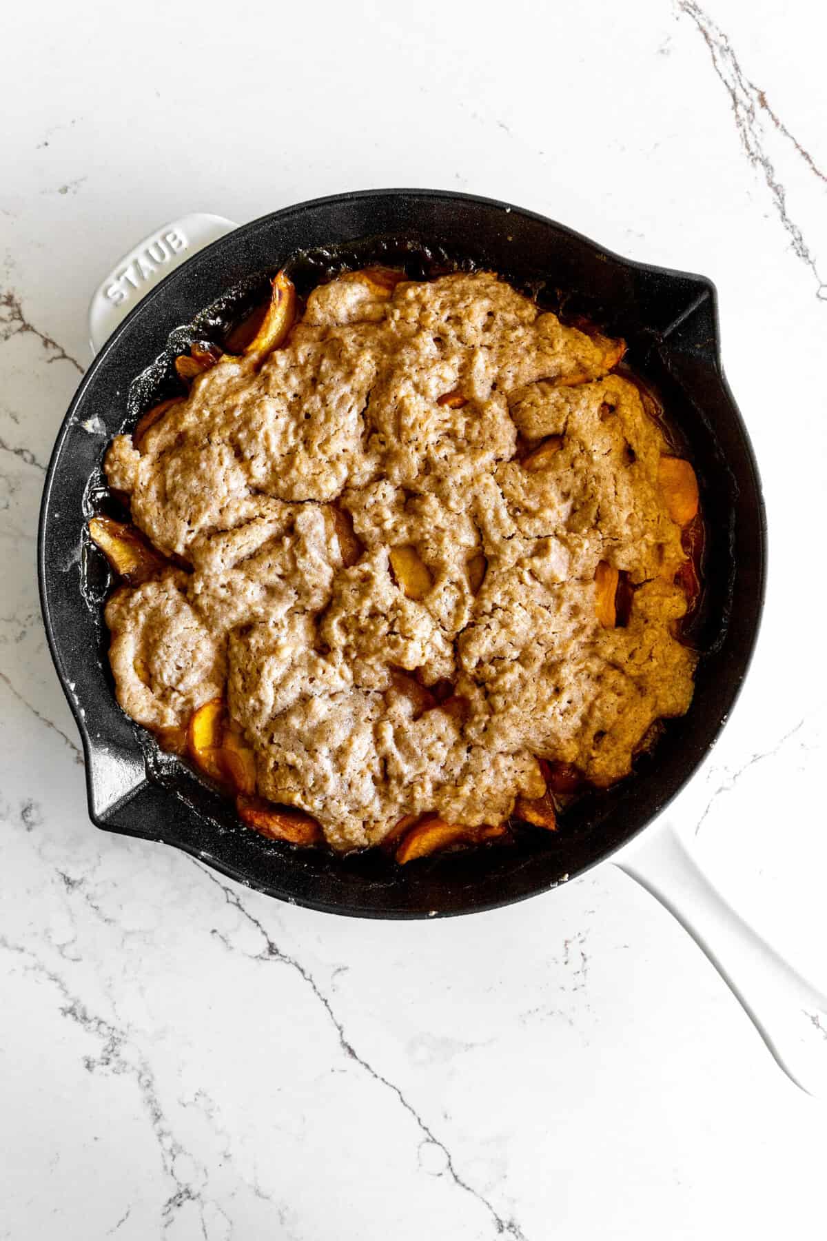 Peach cobbler in a cast iron skillet.