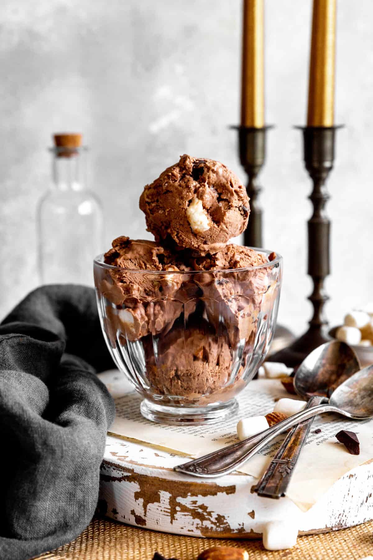Glass dish of rocky road ice cream with two spoons.