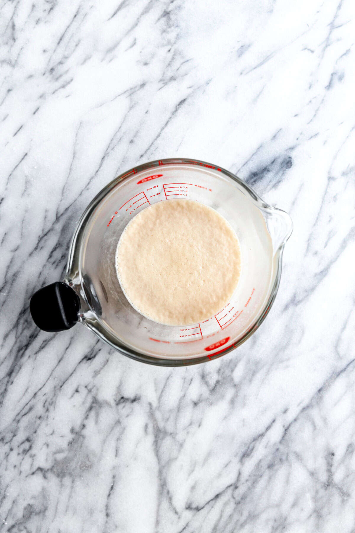 Bloomed yeast in a glass measuring cup.