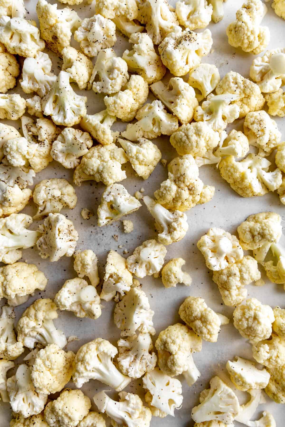 Cauliflower florets on a baking sheet.