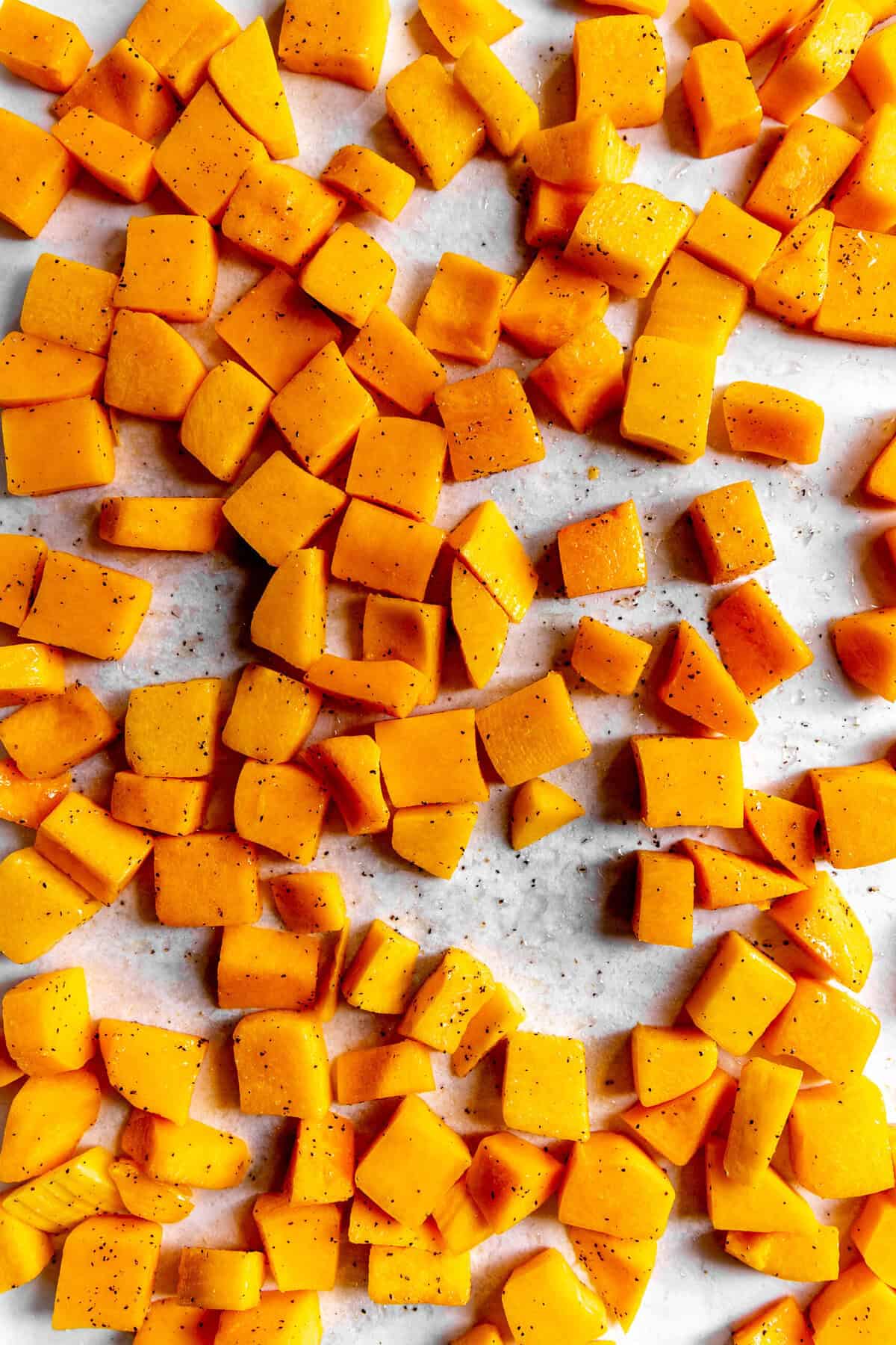 Cubed butternut squash on a baking sheet.