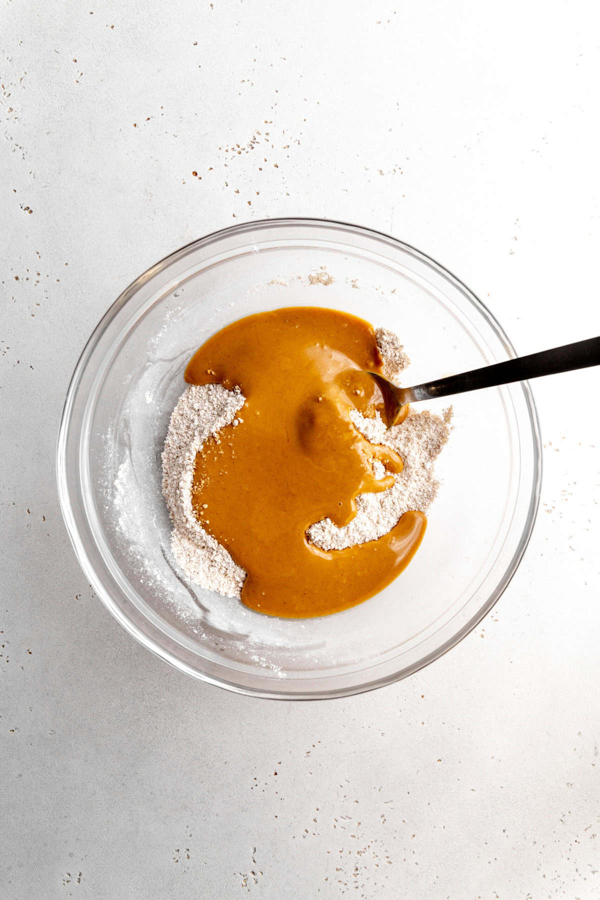 Melted peanut butter and graham cracker crumbs in a glass bowl.