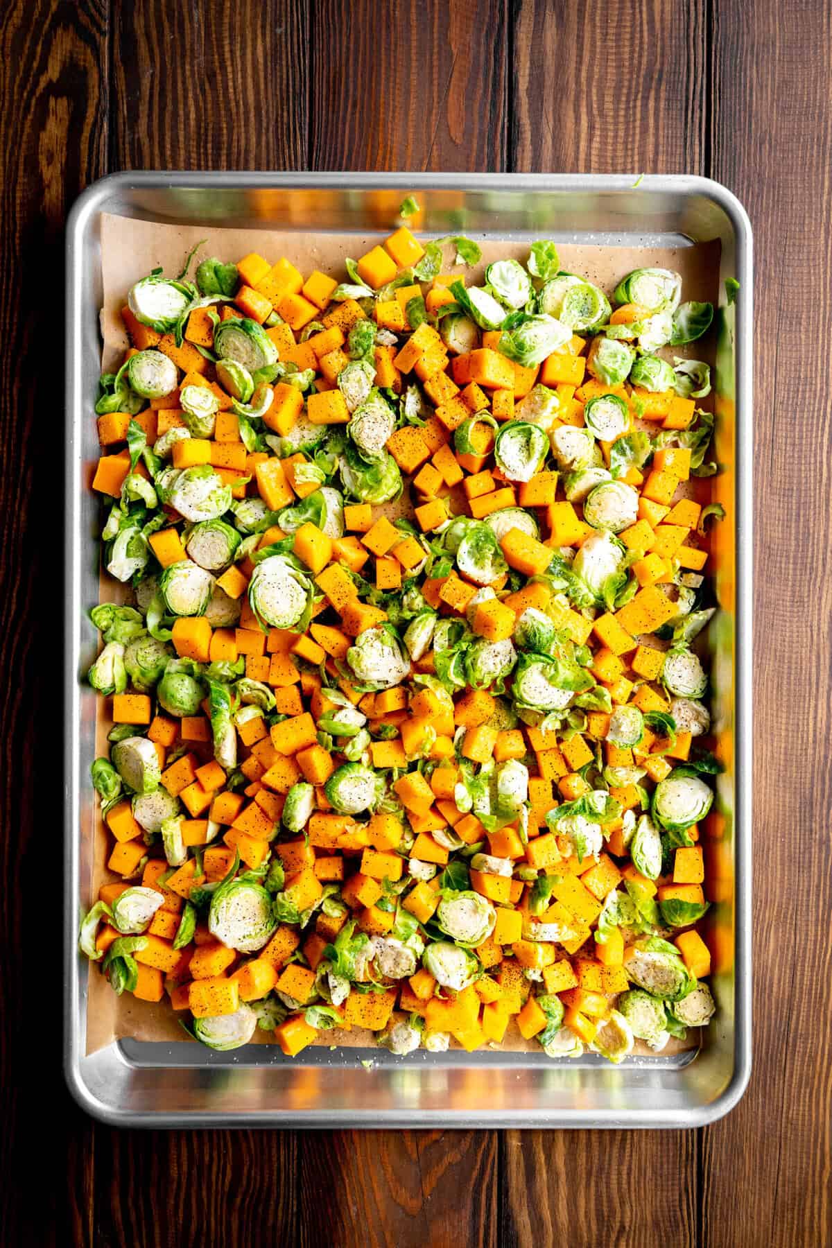 Butternut squash and shredded brussels sprouts on a baking sheet.