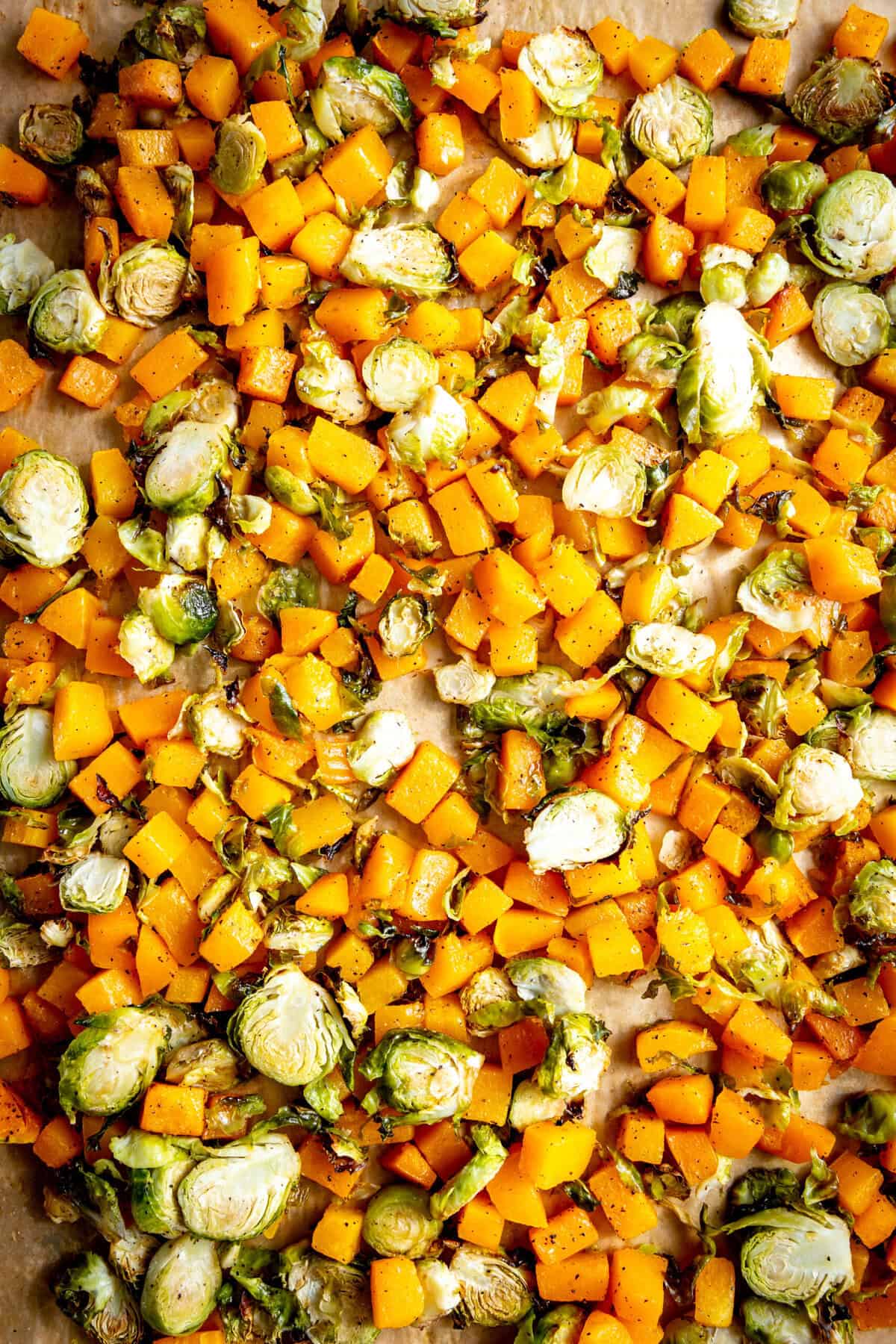 Roasted squash and brussels sprouts on a baking sheet.