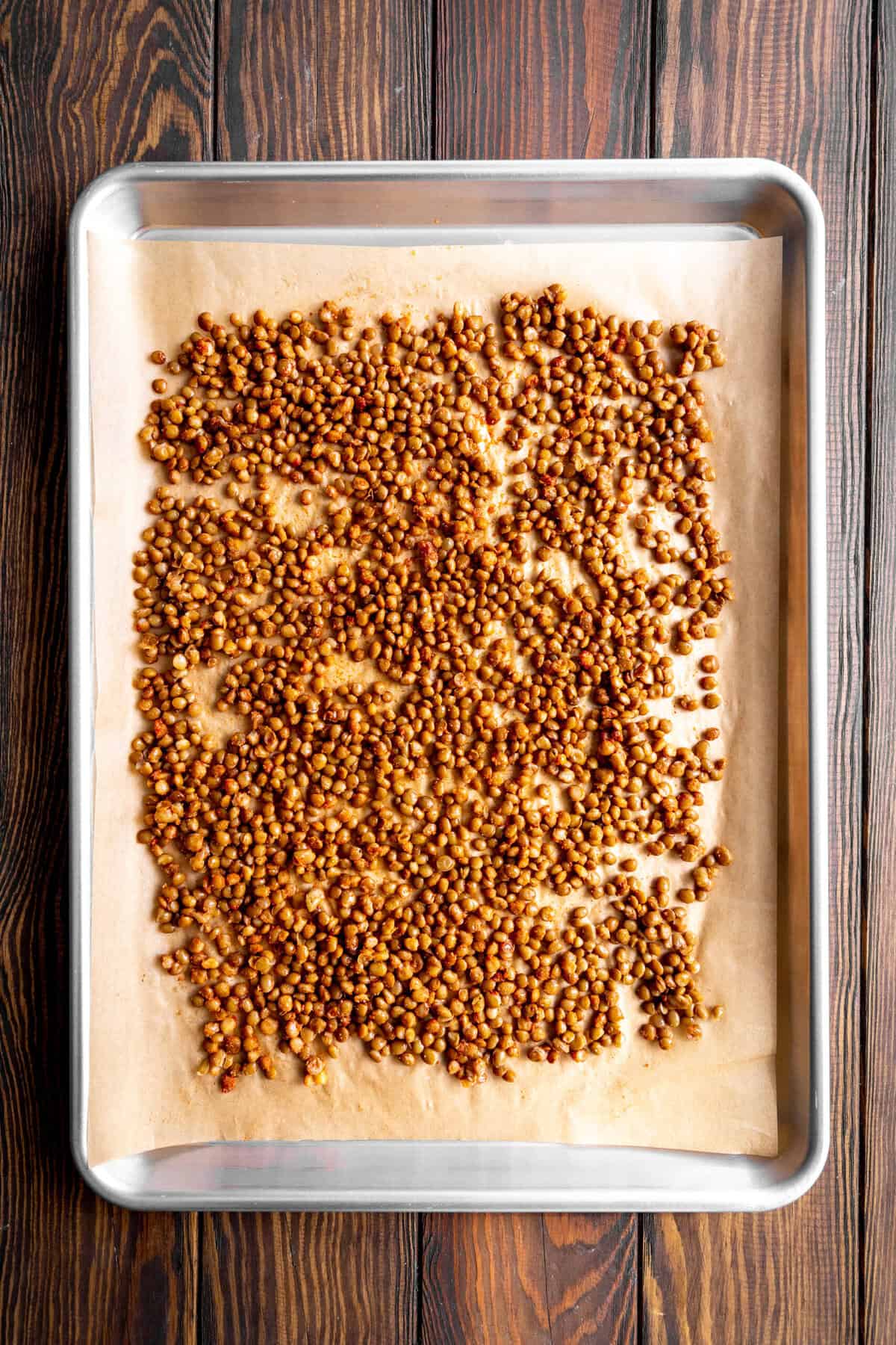 Lentils on a baking sheet lined with parchment paper.