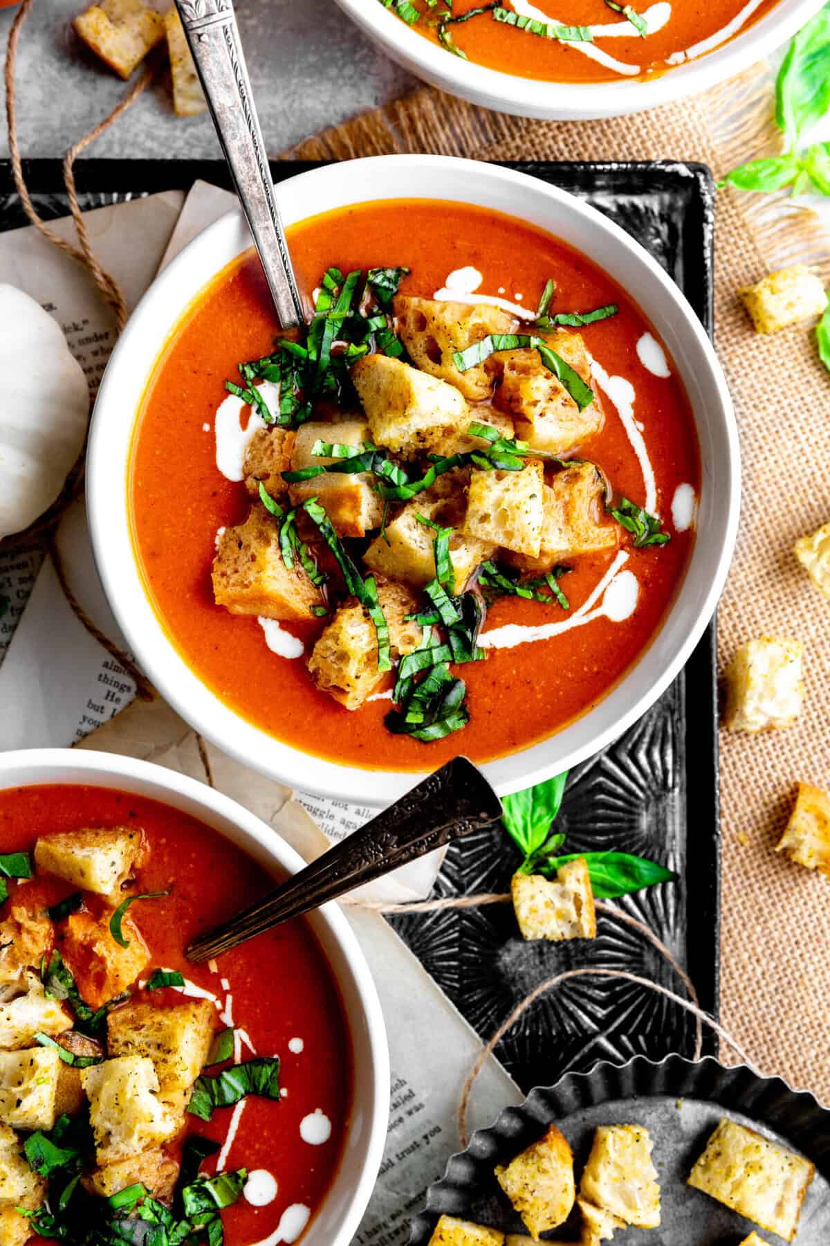 Pumpkin tomato soup in bowls with spoons.