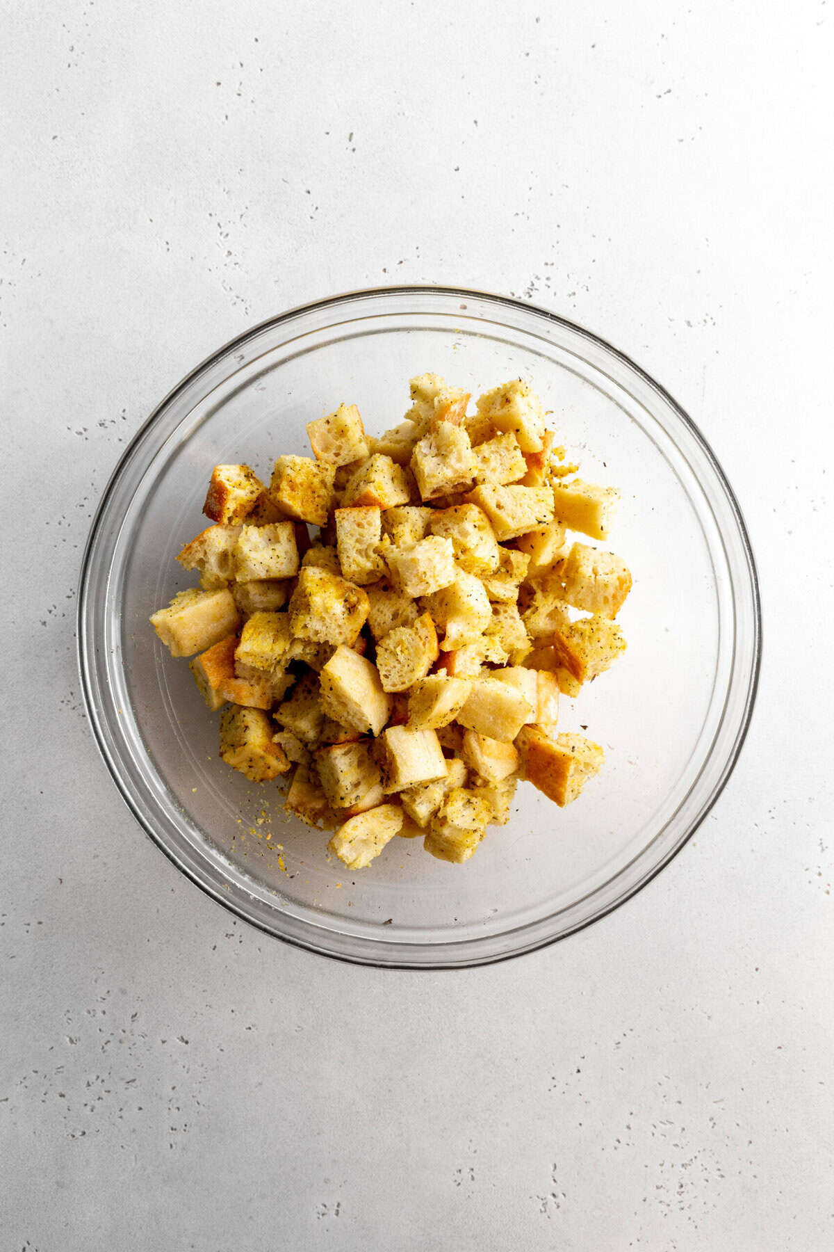 Bread cubes and spices in a glass bowl.