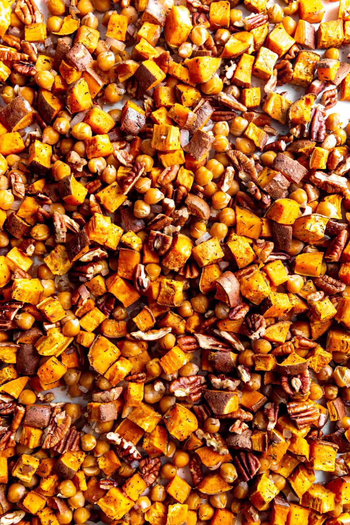 Roasted sweet potatoes, chickpeas and pecans on a baking sheet.