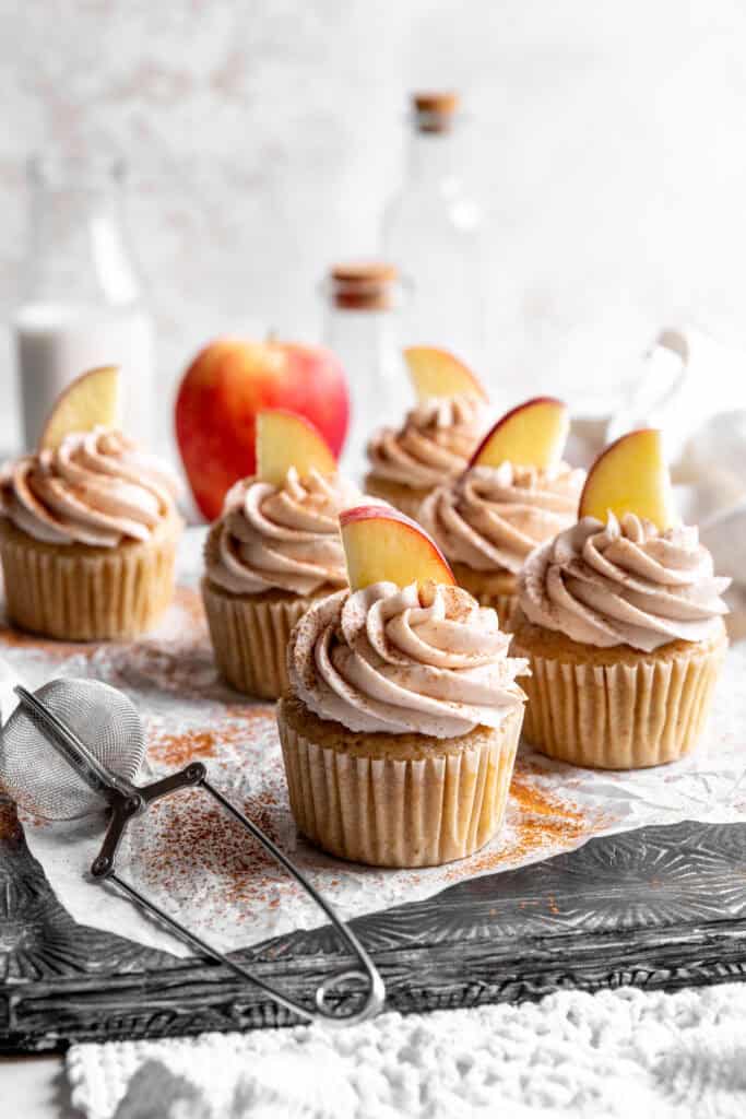 Apple cinnamon cupcakes, apples and a jug of milk.