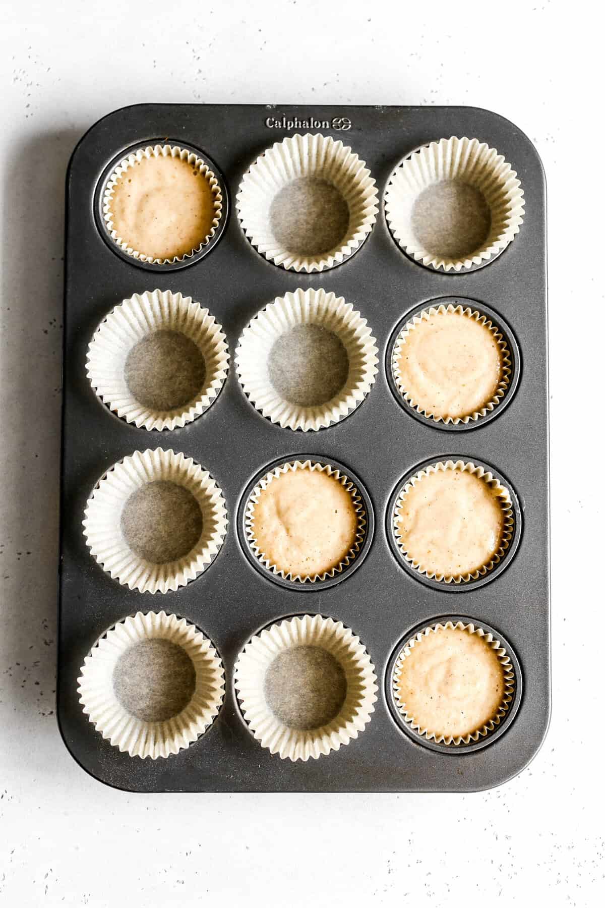Unbaked apple cinnamon cupcakes in a cupcake pan.
