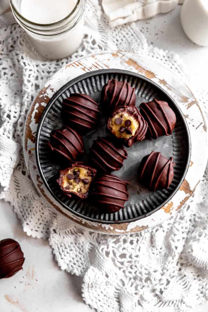 Cookie dough bites on a metal plate and a glass of milk.