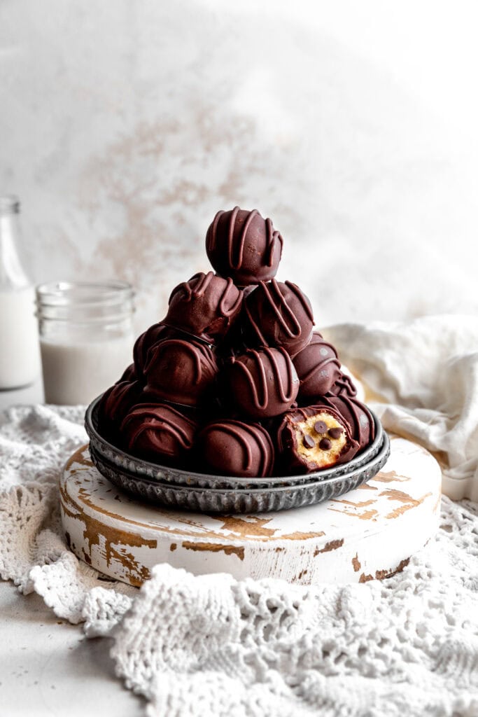 Stack of cookie dough bites and a glass of milk.