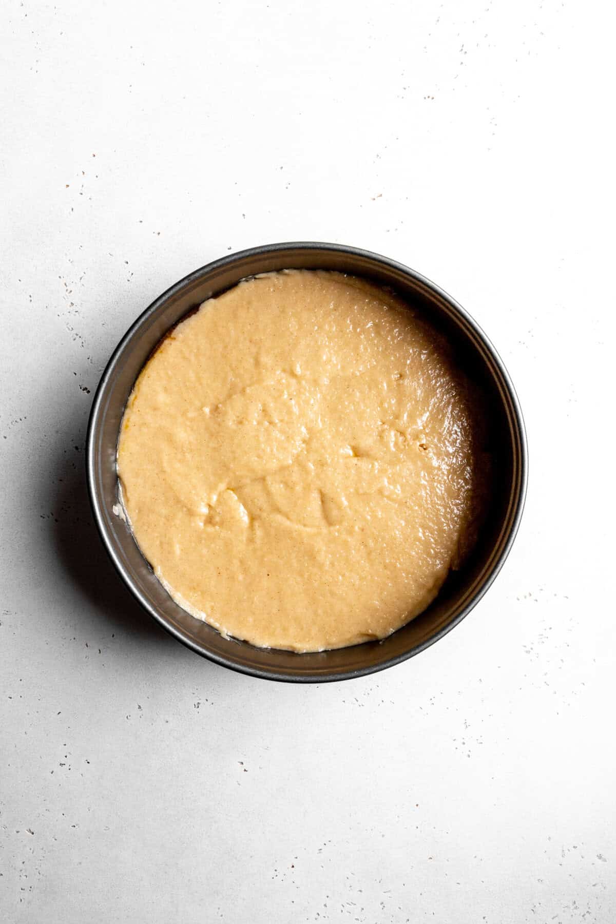 Unbaked pear upside down cake in a pan.
