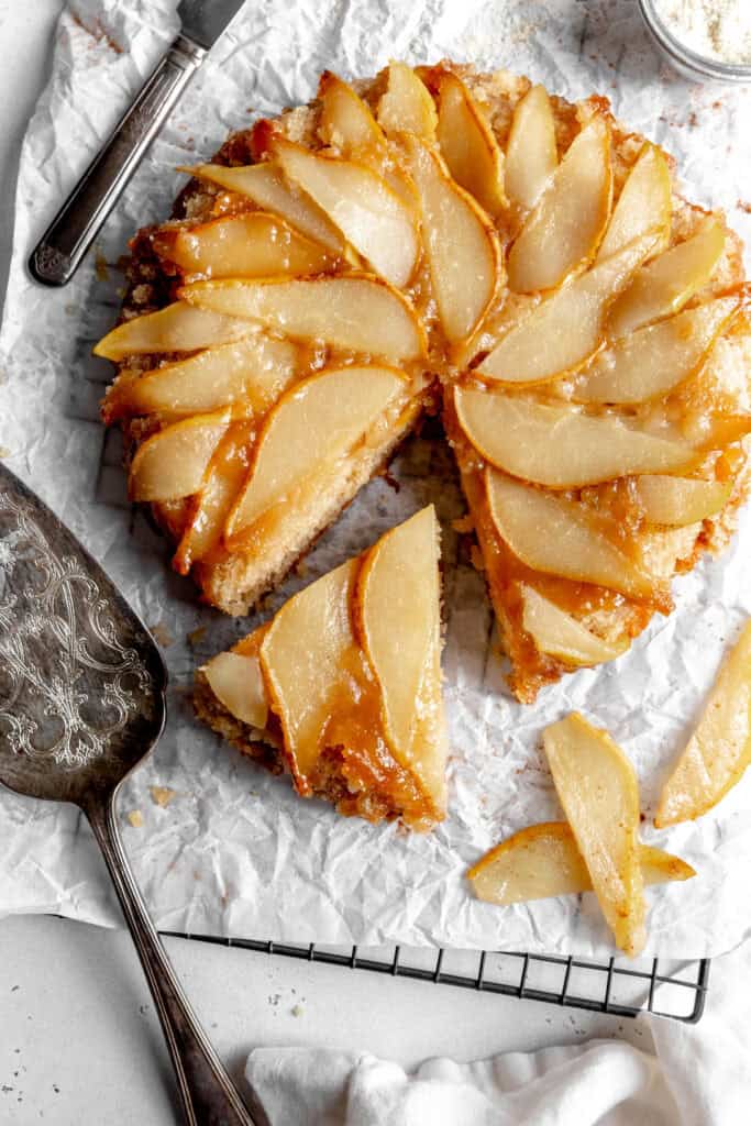 Pear upside down cake on a sheet of parchment paper.