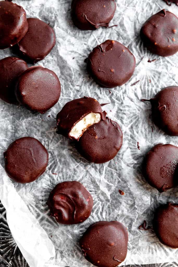 Peppermint patty with a bite taken out of it on a baking sheet with more candies.