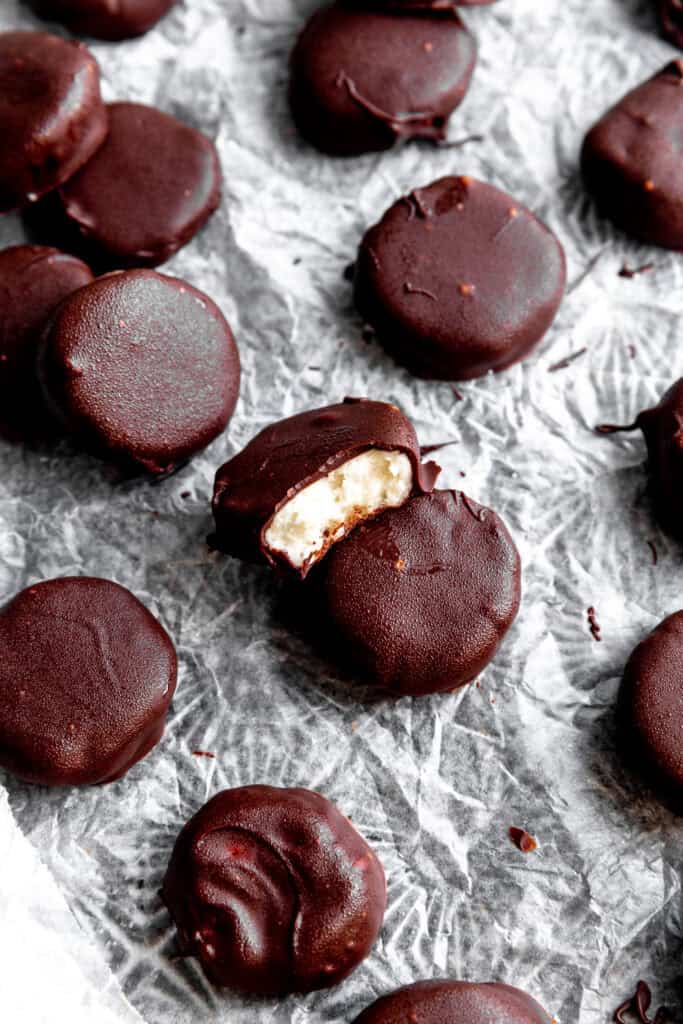 Peppermint patty with a bite taken out of it on a baking sheet with more candies.