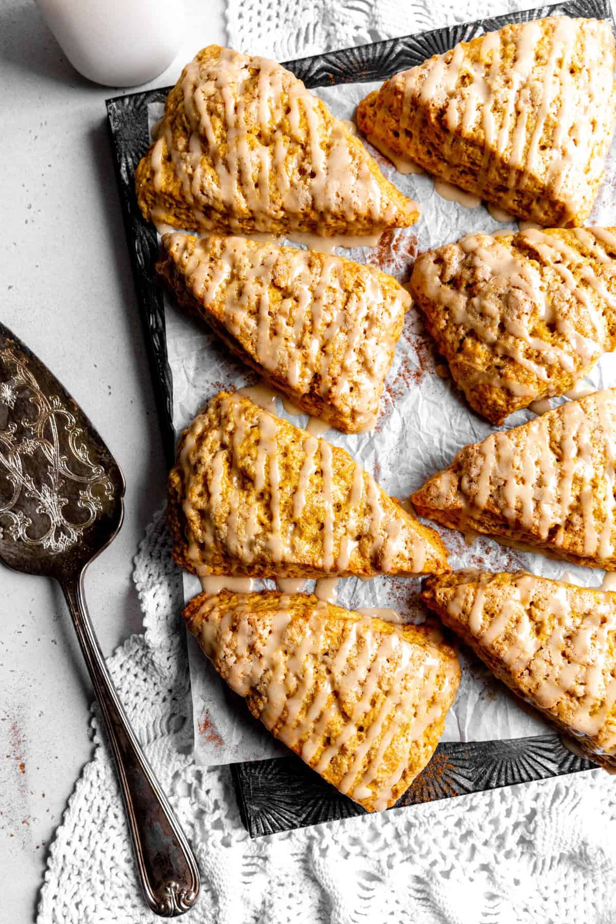 Pumpkin scones drizzled with maple glaze and a jug of milk.