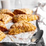 Pumpkin scone, a spoon covered in maple glaze and a linen napkin.