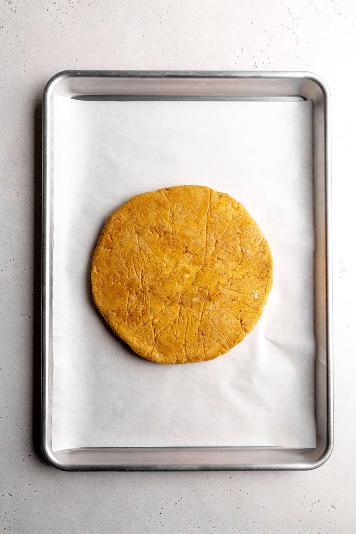 Pumpkin scone dough rolled out in a circle.