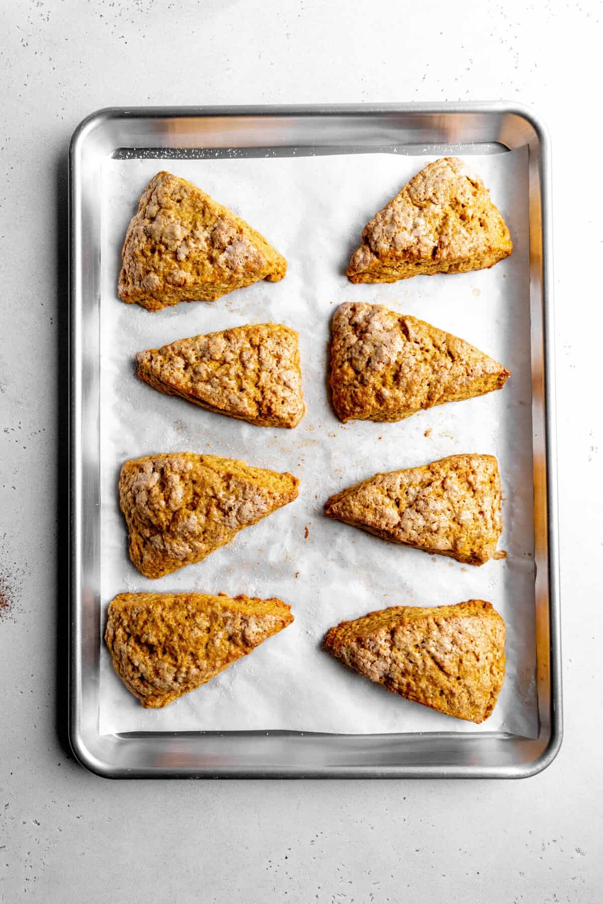 Baked pumpkin scones on a baking sheet.