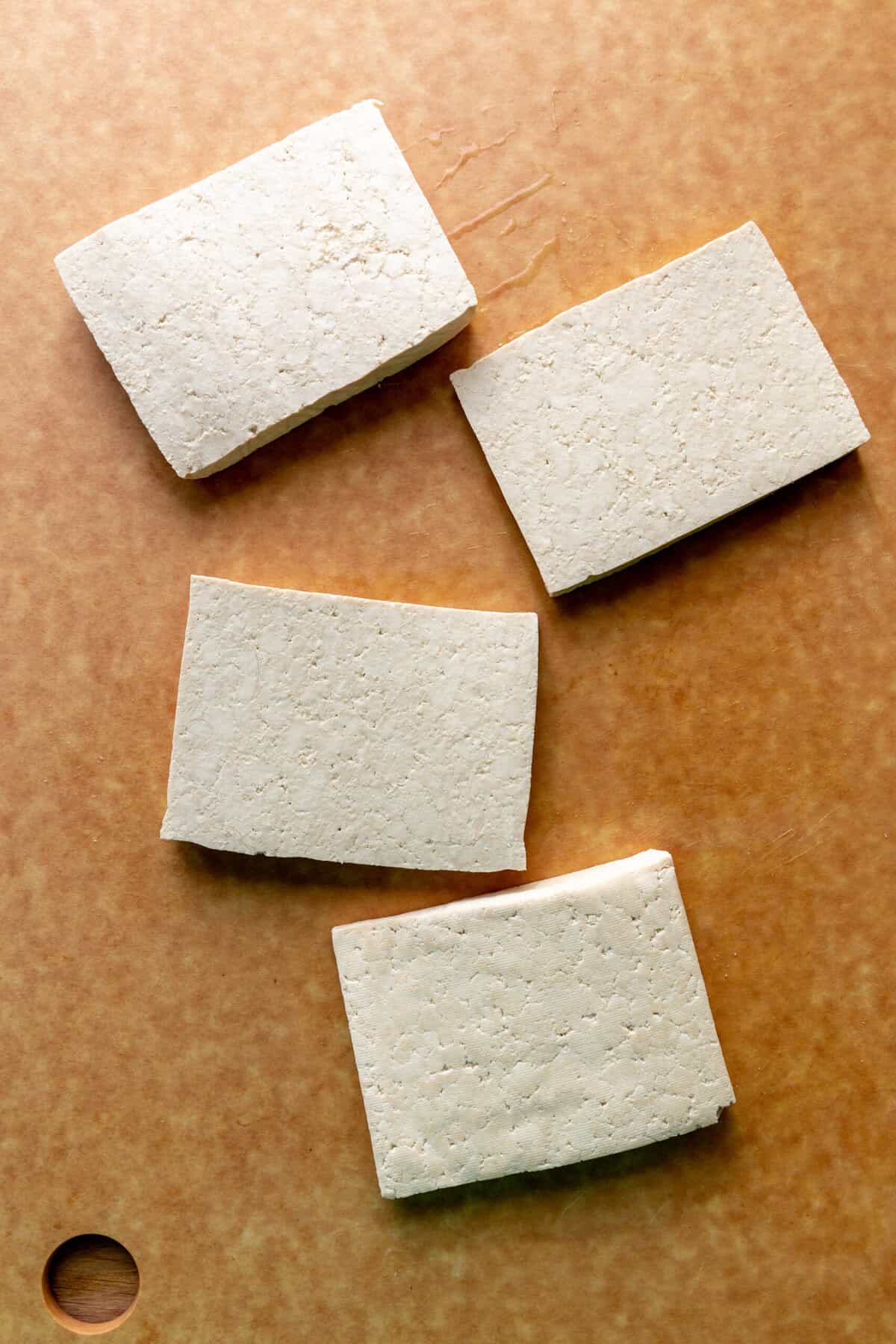 Slabs of tofu on a cutting board.