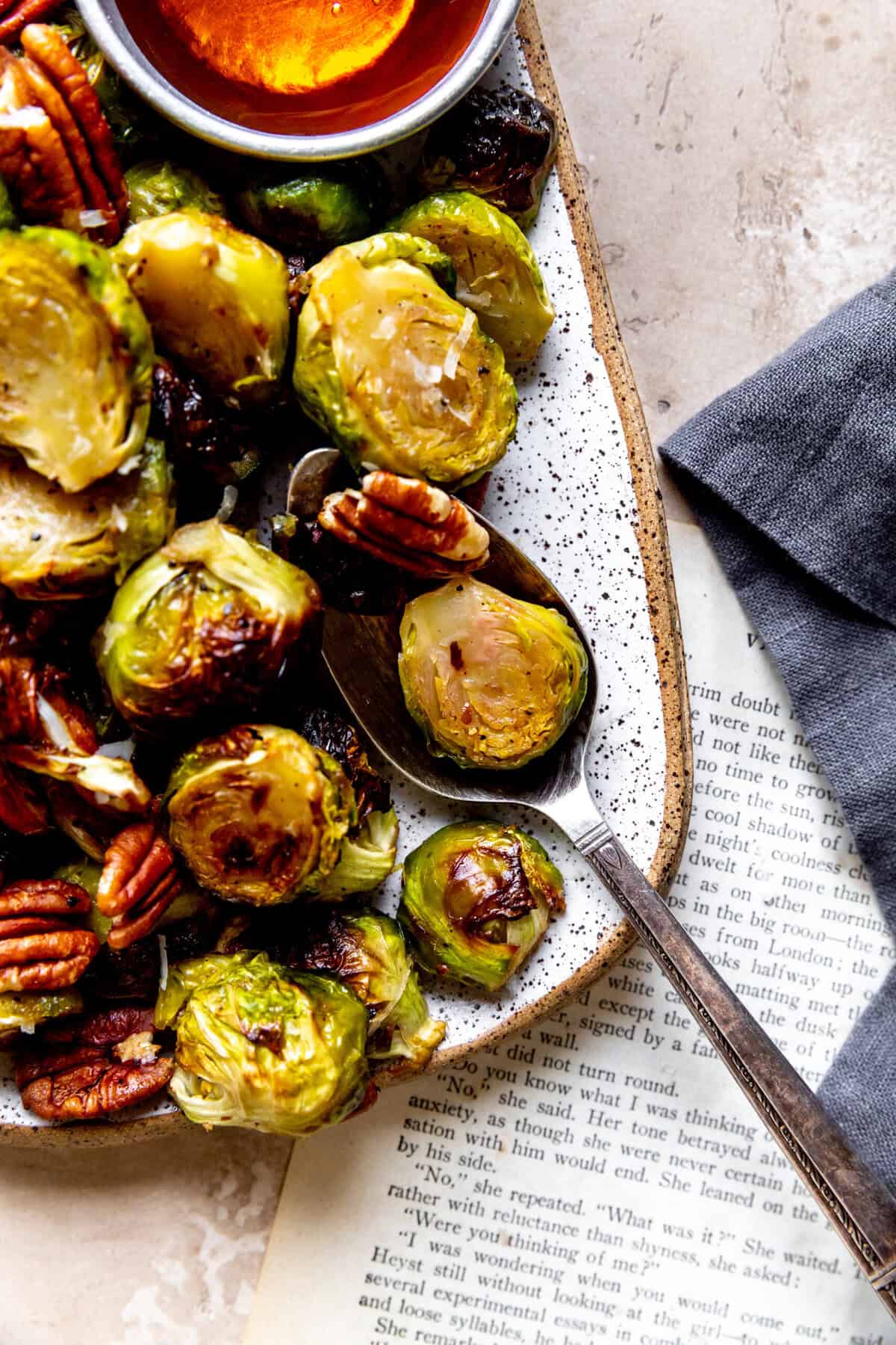 Spoon digging into a dish of roasted brussels sprouts.