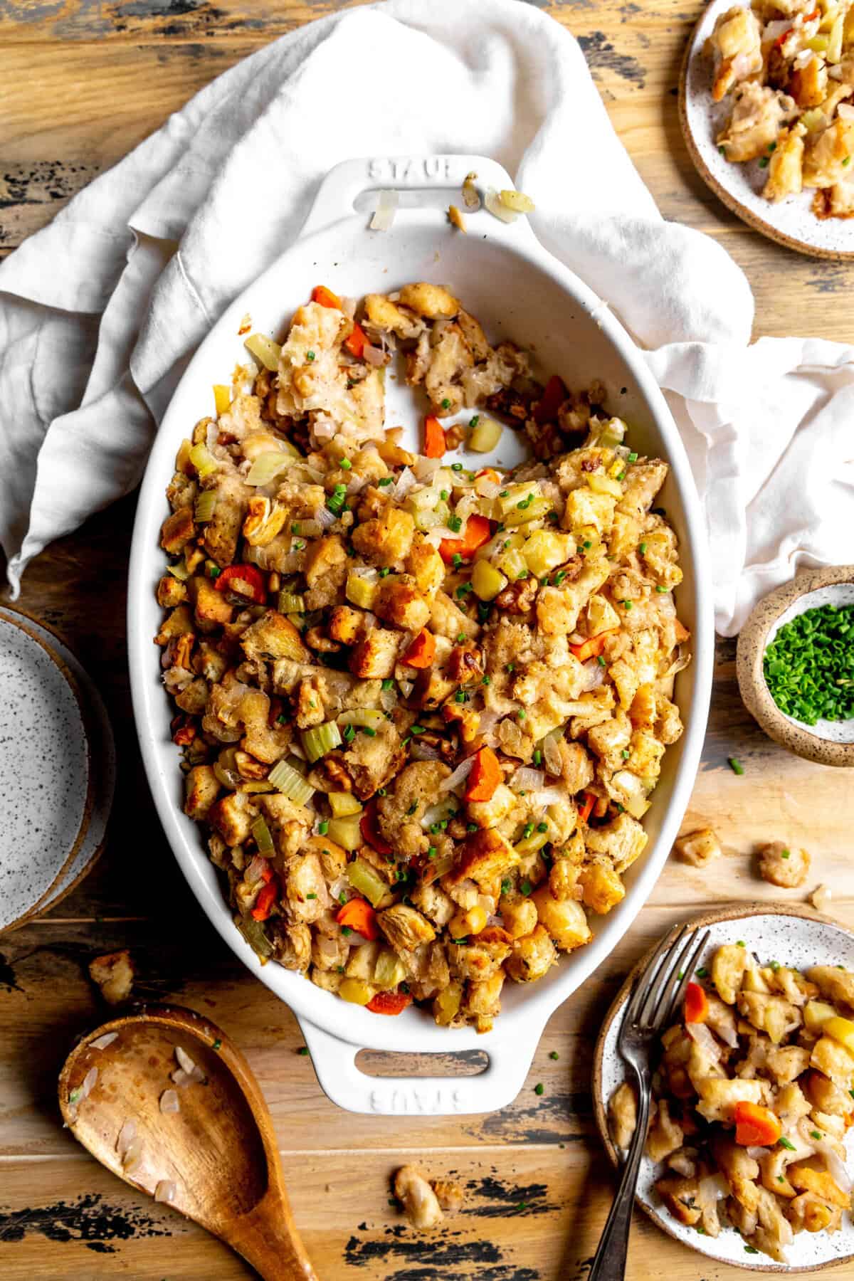 Casserole dish of stuffing and two small plates of stuffing.