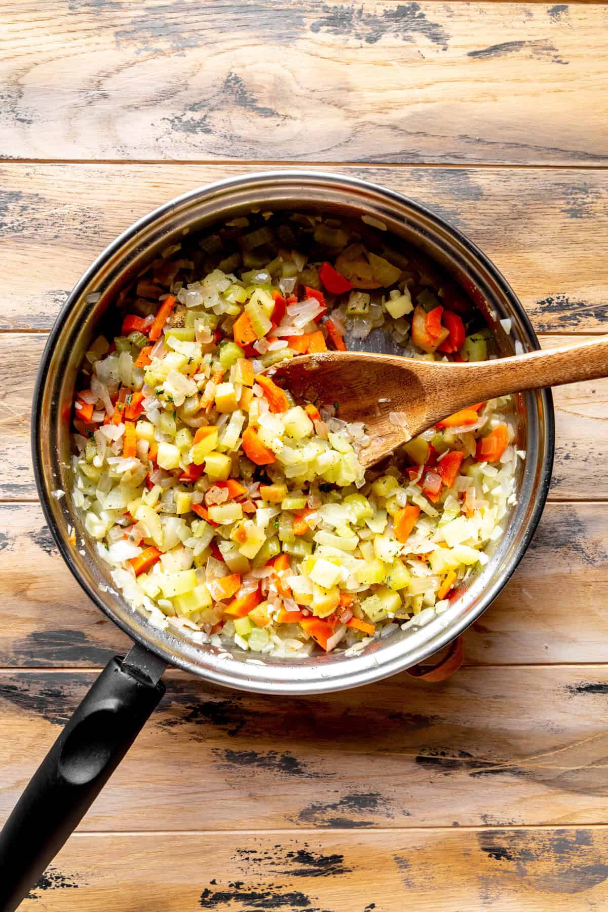 Cooked onions, celery, carrots, apples and garlic in a skillet.