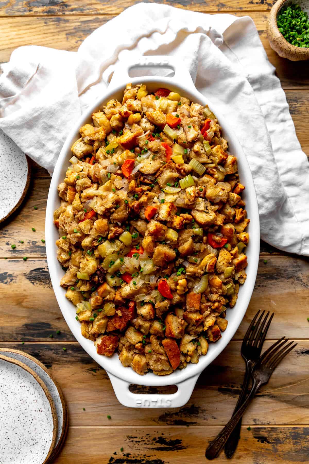Baked vegan stuffing in a casserole dish and a white linen napkin.