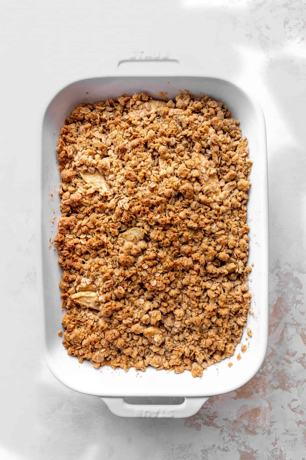 Baked apple crisp in a white casserole dish.