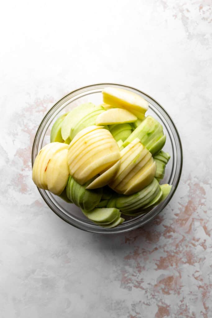 Glass bowl of peeled apple slices.